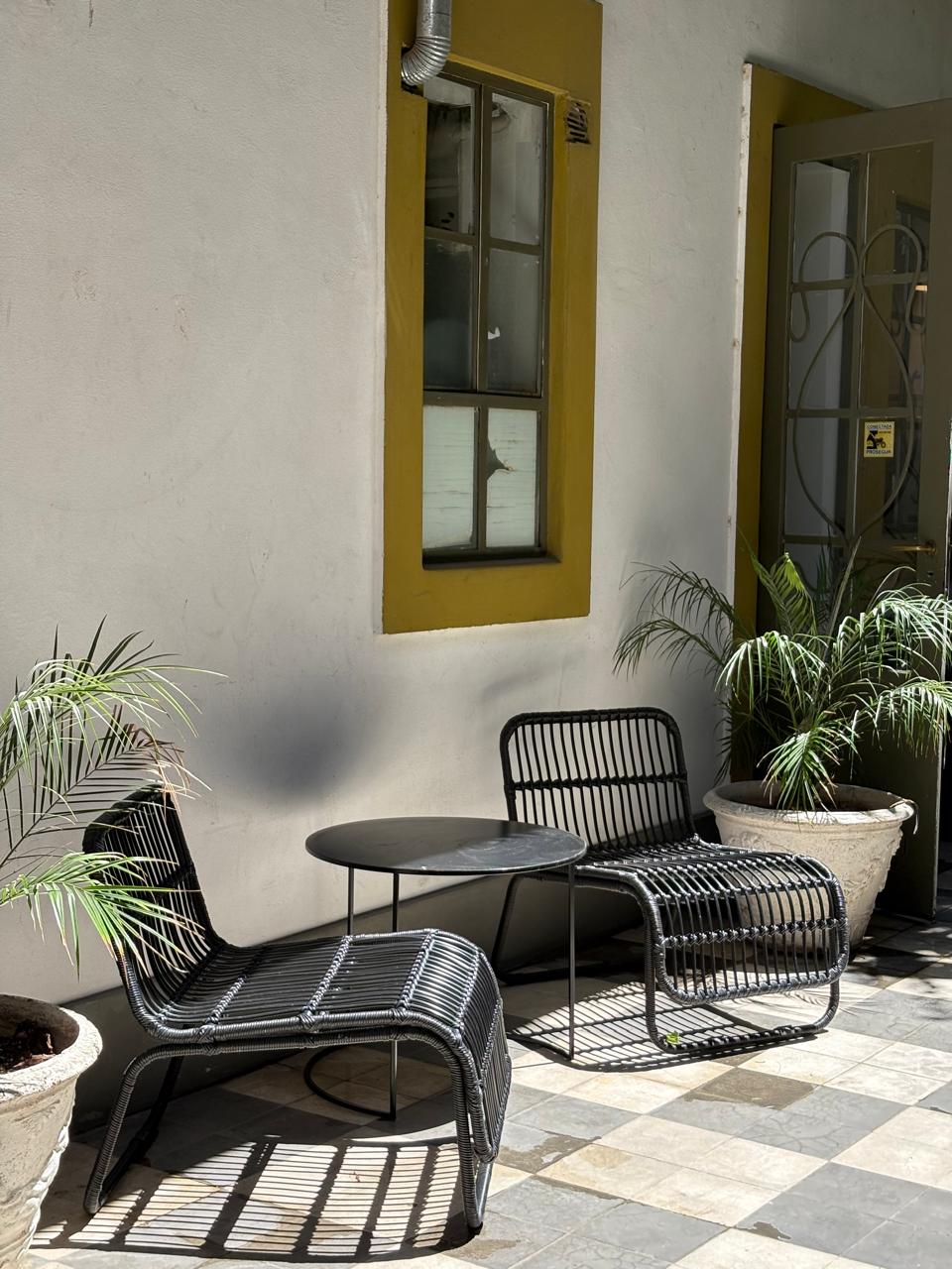 Rincón de descanso con sillones tejidos y vegetación
