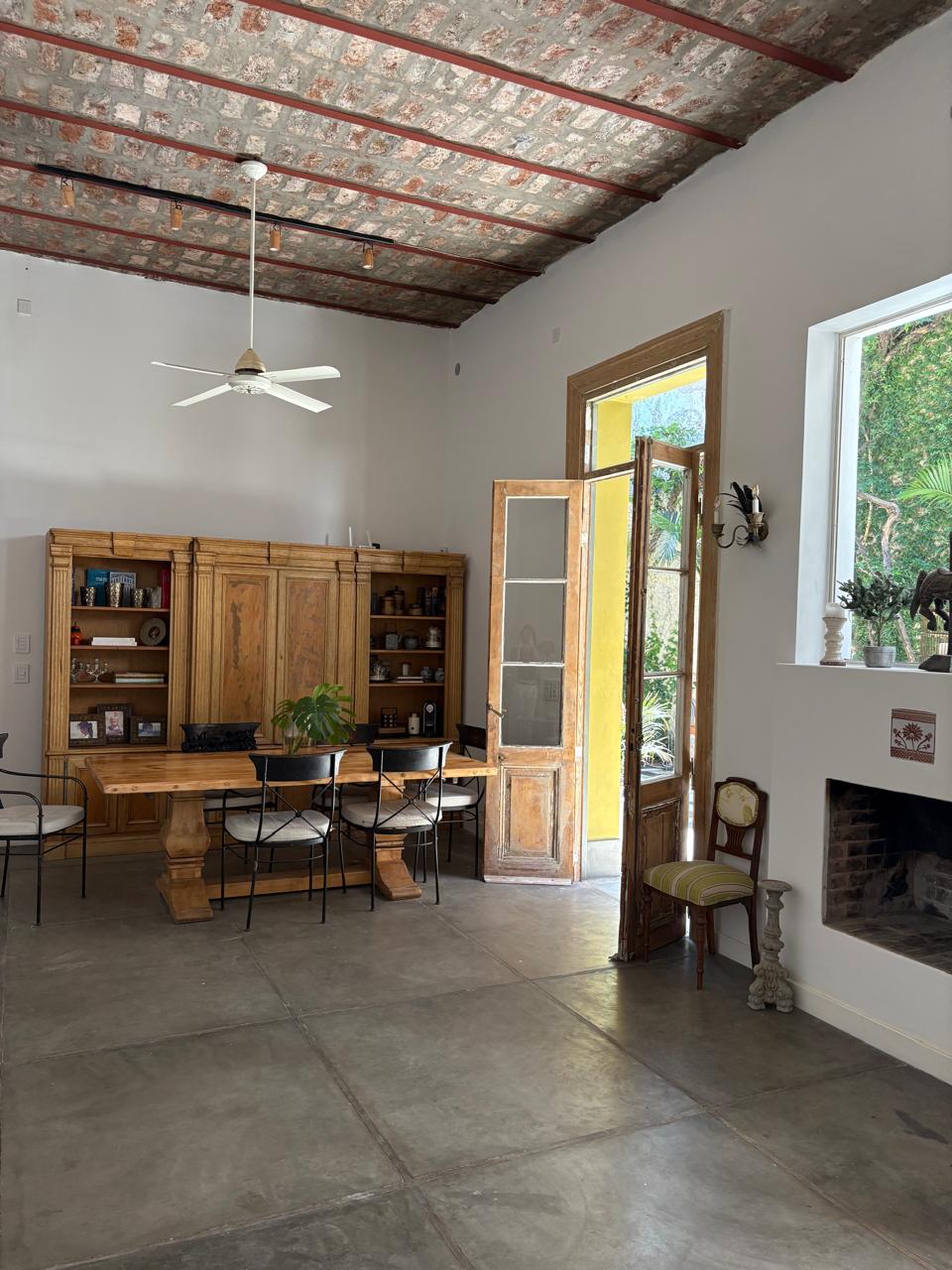 Salón interior con mesa, biblioteca y techo de ladrillo